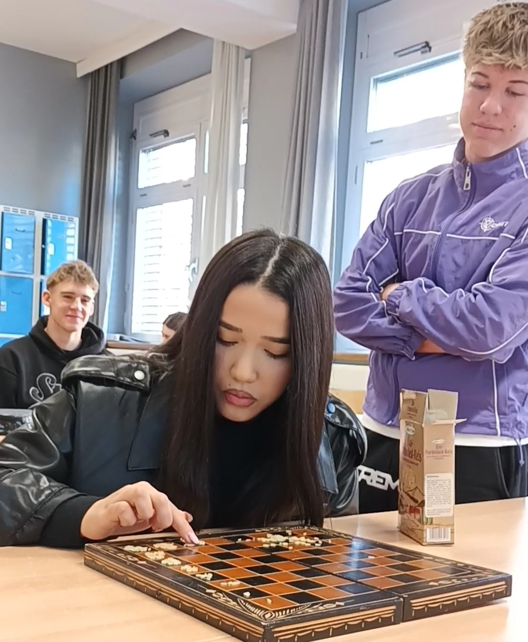 Farsane Mohammadi and Matthias Gressenbauer with Markus Lumplecker demonstrating geometric series with chessboard rice grain problem